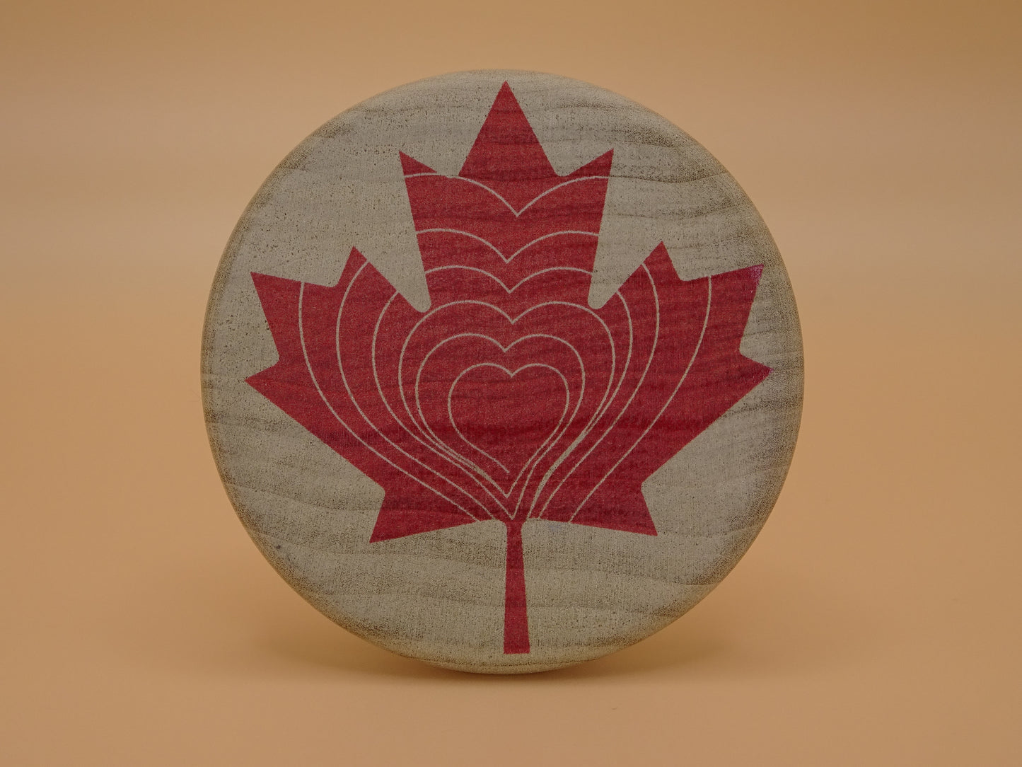 "Compassion Compass" Canadian Edition-Smooth wooden disc with a red maple leaf design on Maple Wood