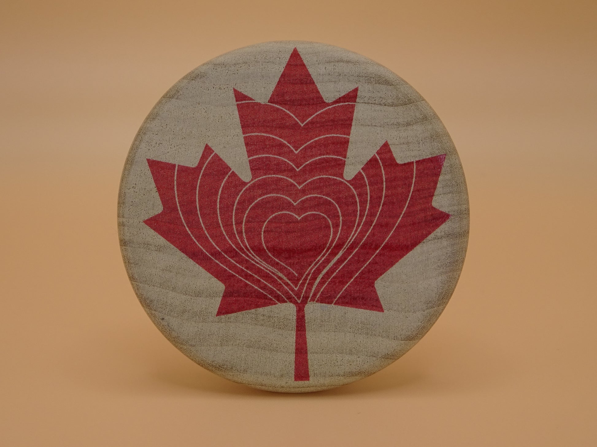 "Compassion Compass" Canadian Edition-Smooth wooden disc with a red maple leaf design on Maple Wood