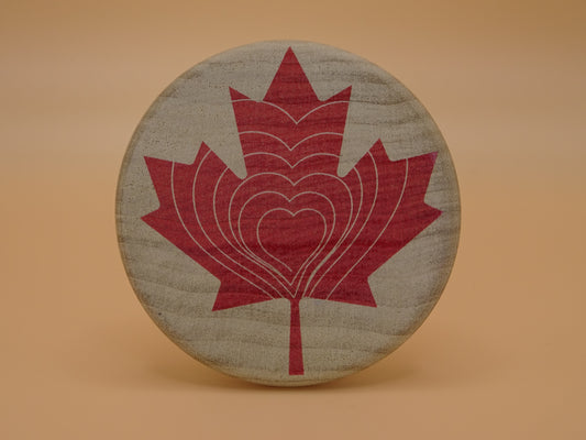 "Compassion Compass" Canadian Edition-Smooth wooden disc with a red maple leaf design on Maple Wood