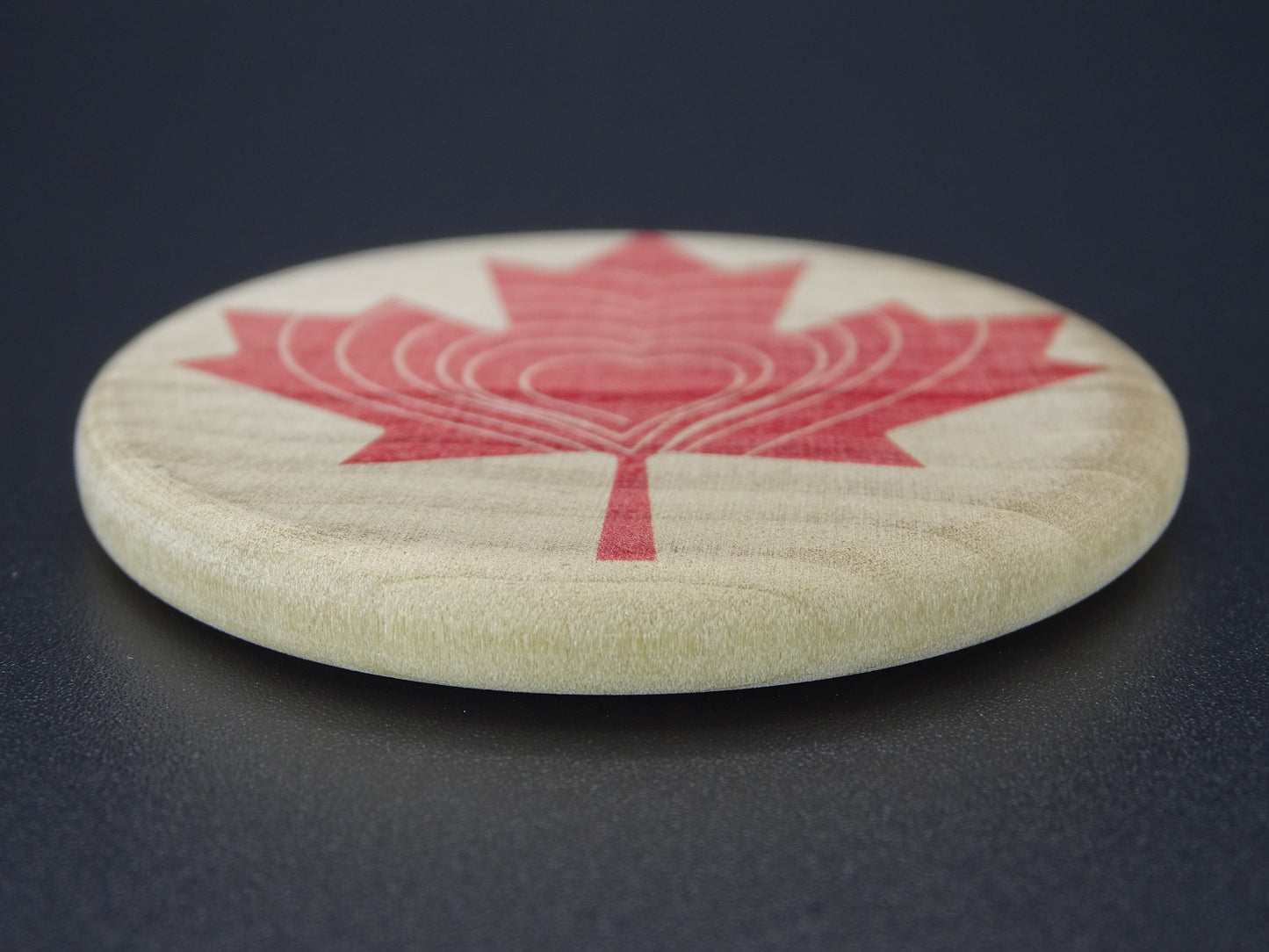 "Compassion Compass" Canadian Edition-Smooth wooden disc with a red maple leaf design on Maple Wood