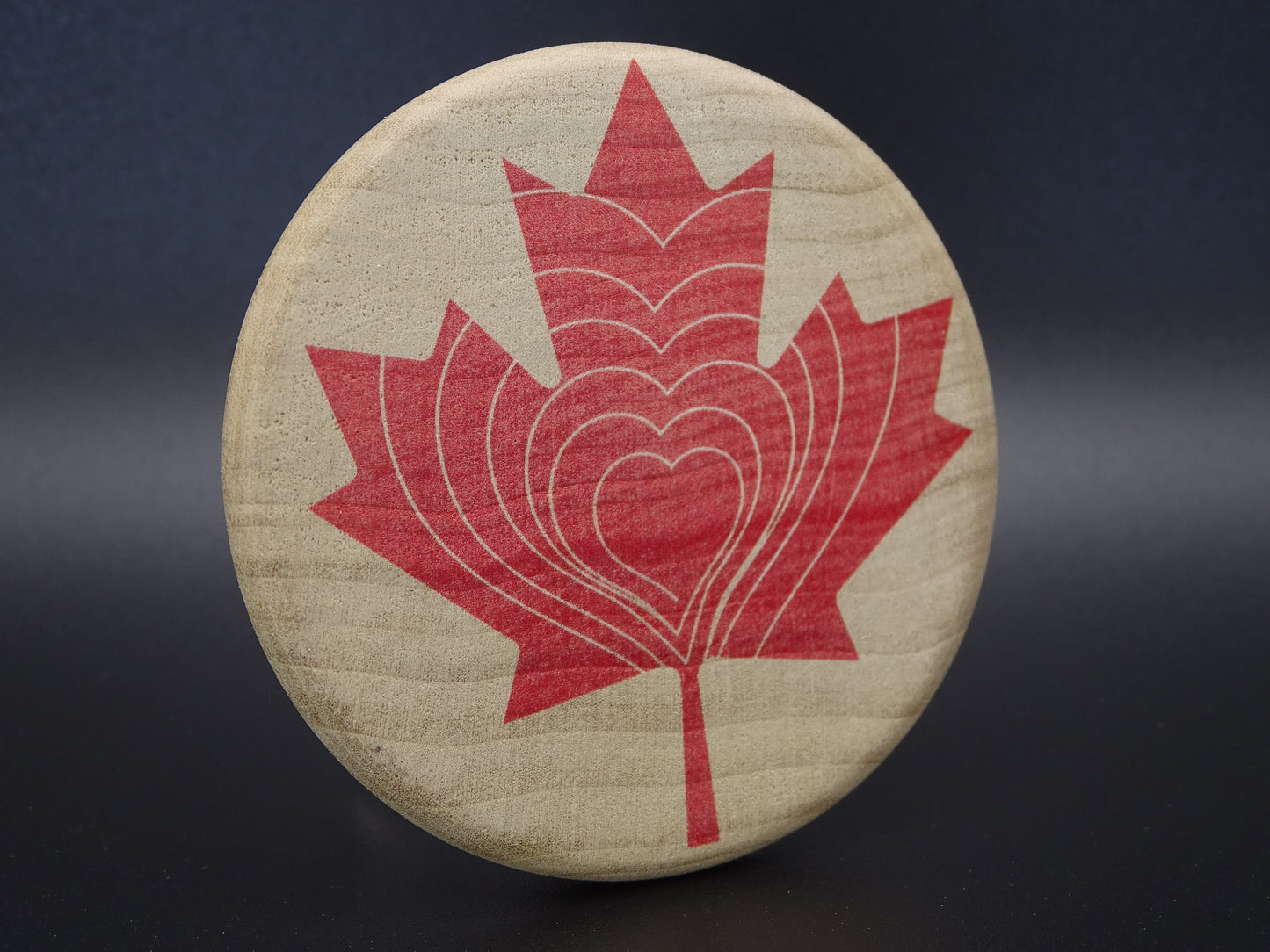 "Compassion Compass" Canadian Edition-Smooth wooden disc with a red maple leaf design on Maple Wood