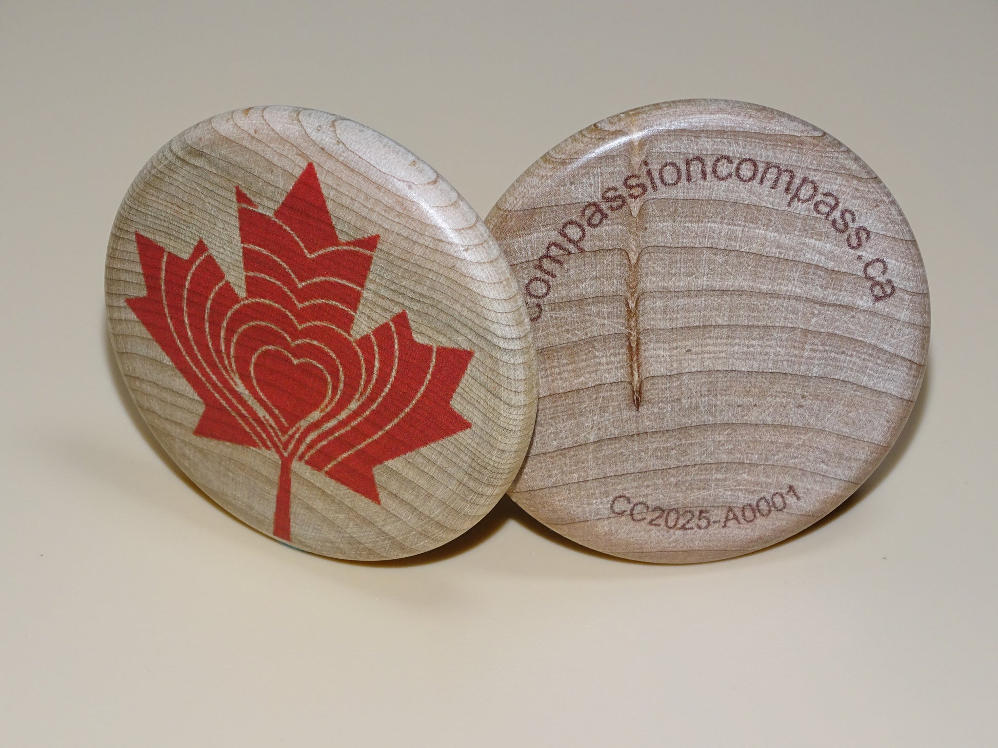 Compassion Compass-Both sides of wooden disc with red maple leaf design and serial number